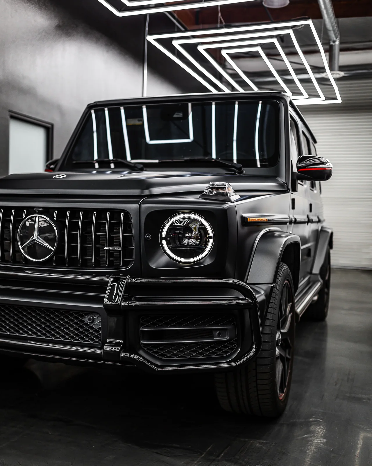 Mercedes-AMG G63 màu đen dưới dàn đèn lục giác trong showroom