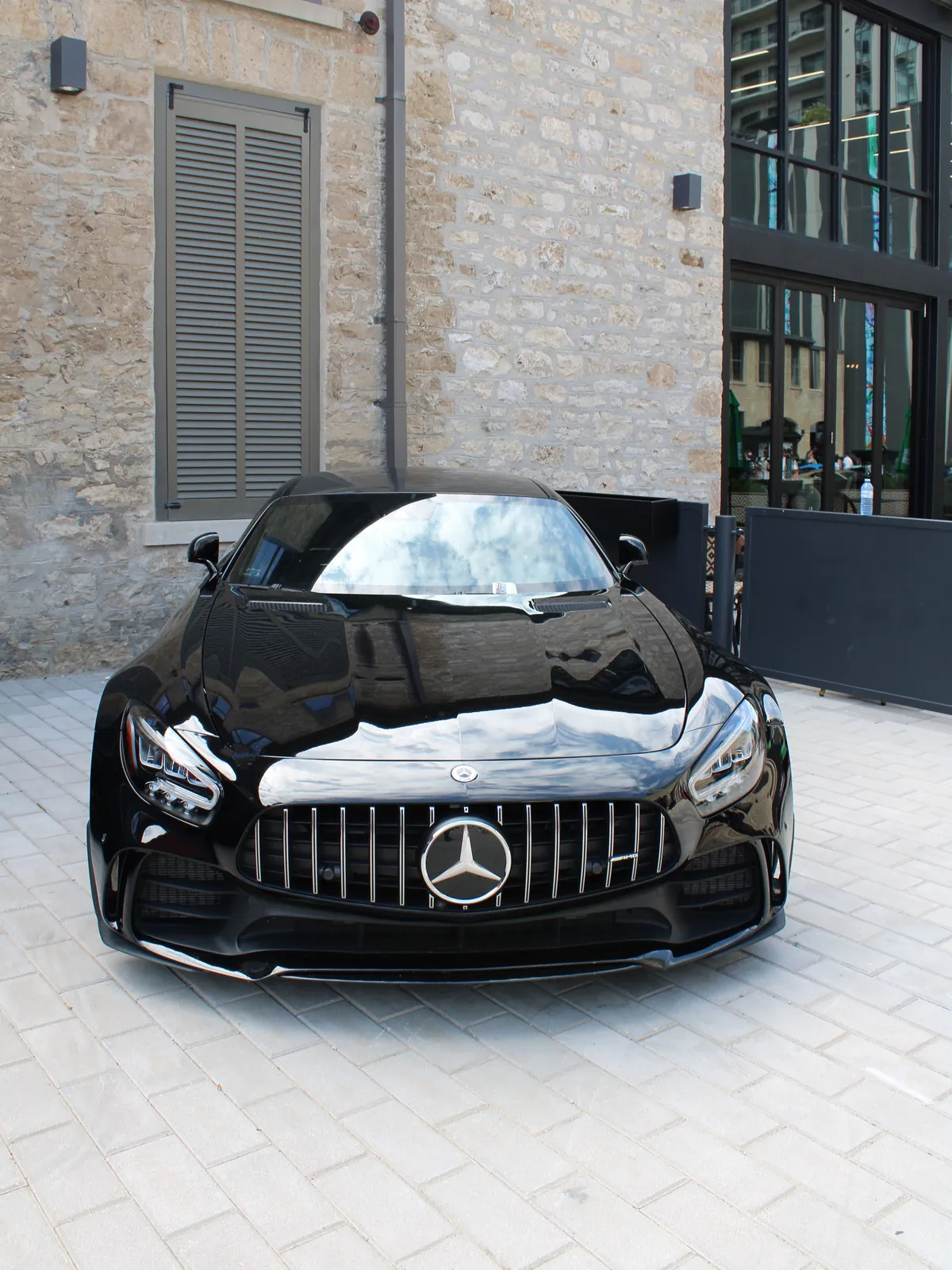 Mercedes-AMG GT màu đen đỗ trước tòa nhà tường đá